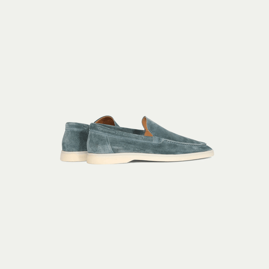 Men's blue slip-on loafers with moc toe stitching and flat cream soles