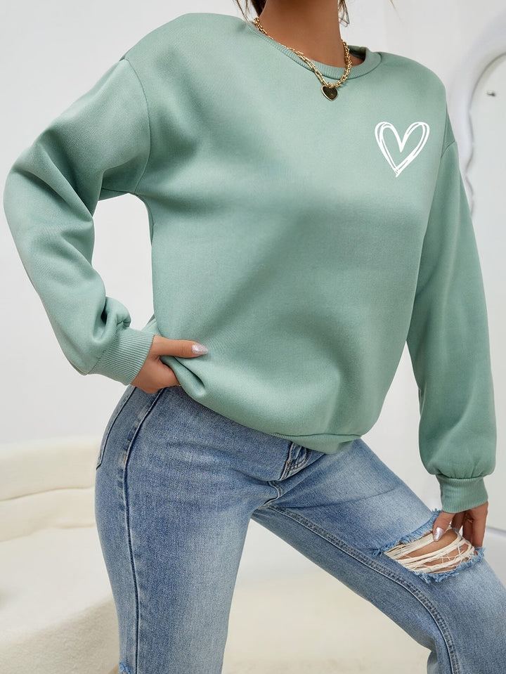 Women's crew neck sweatshirt with long sleeves and heart chest graphic