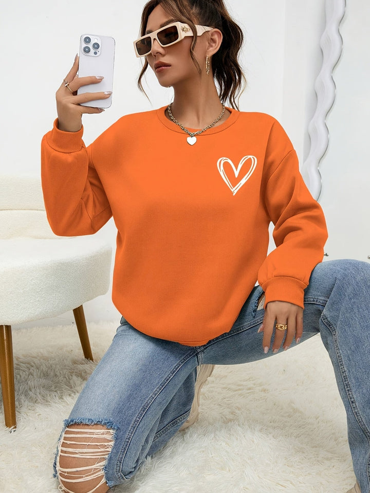 Women's crew neck sweatshirt with long sleeves and heart chest graphic