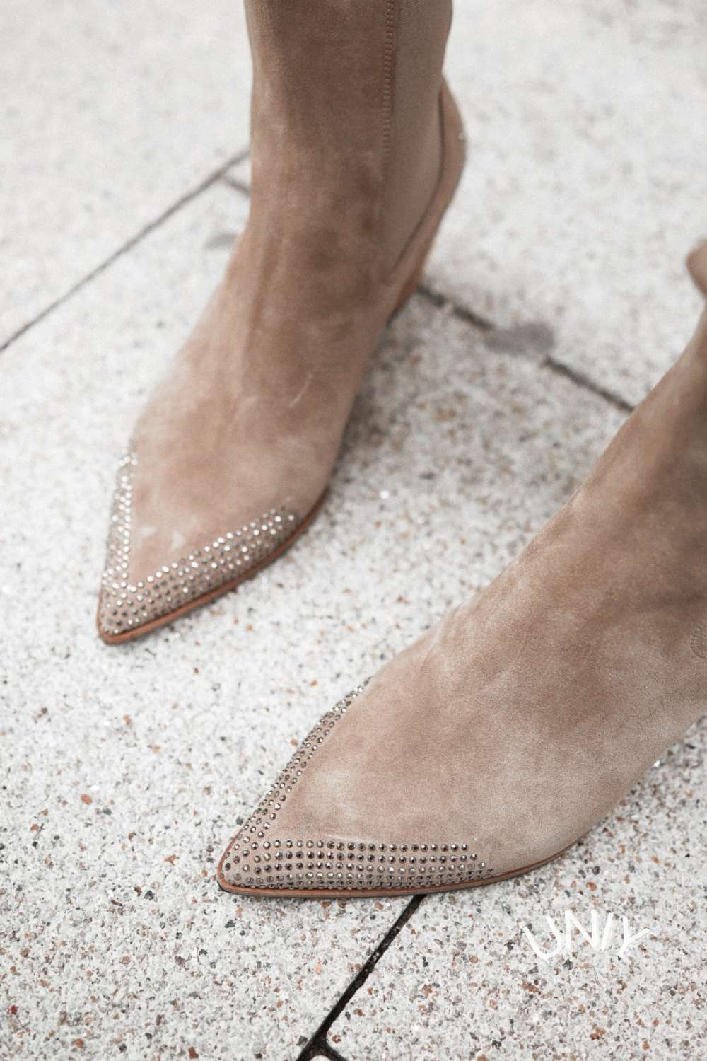 Beige pointed-toe ankle boots with studded western trim