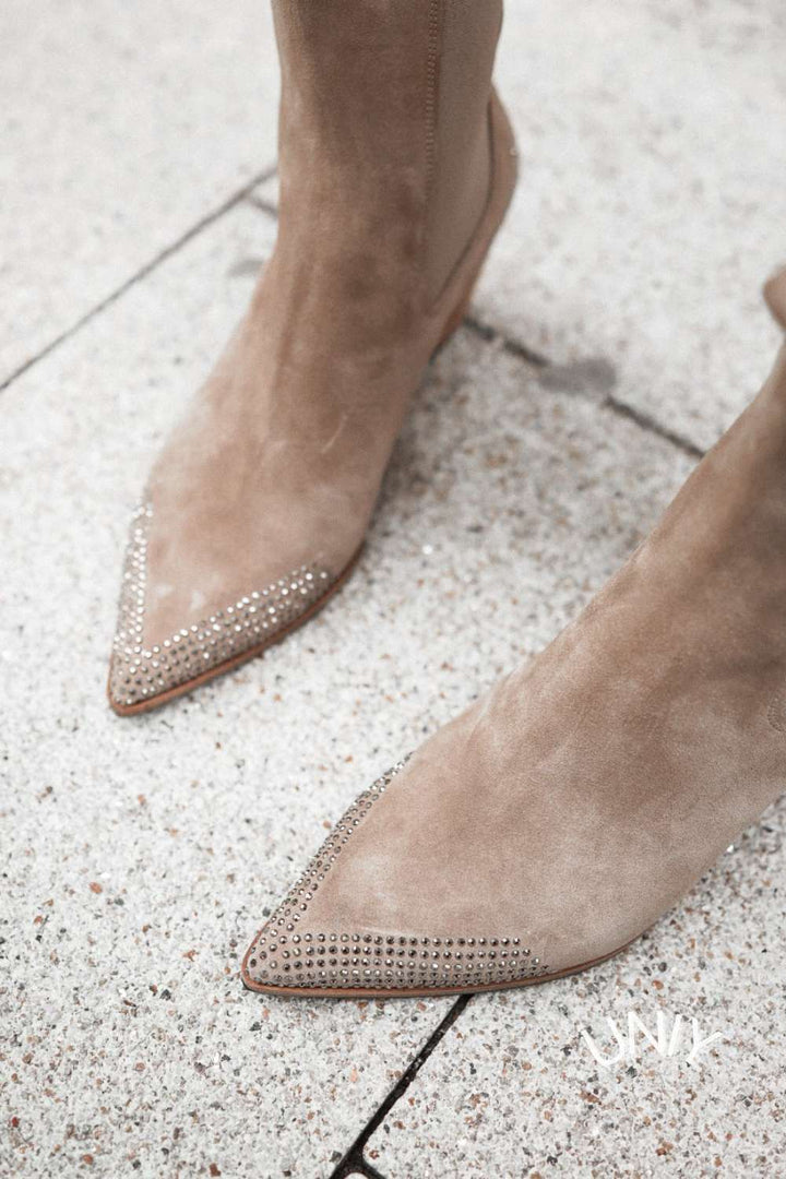 Beige pointed-toe ankle boots with studded western trim