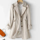 Women's belted double breasted trench coat with long sleeves and flap pockets