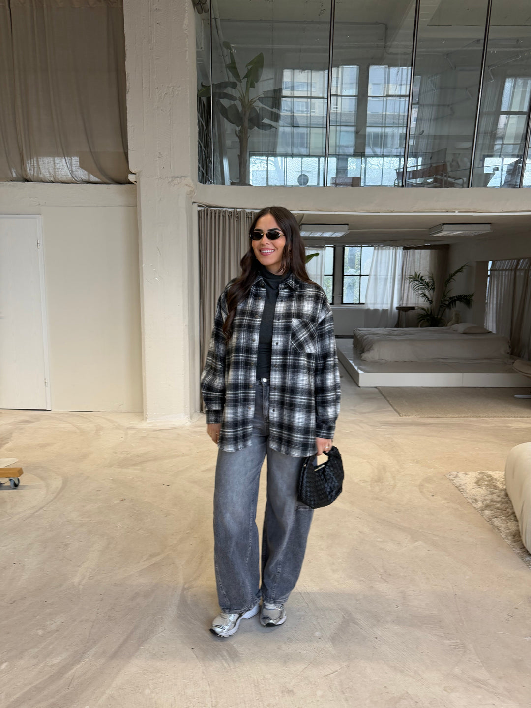 Women's black, gray and white plaid shirt layered over a dark turtleneck