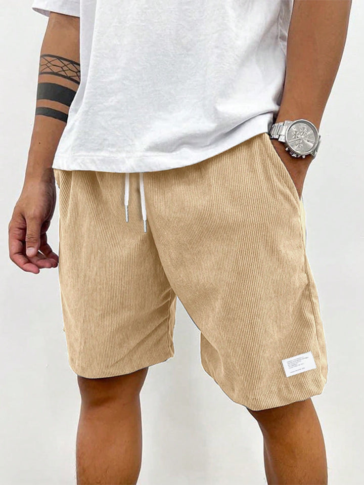 Men's blue corduroy shorts with drawstring waist, relaxed fit, worn with white t-shirt