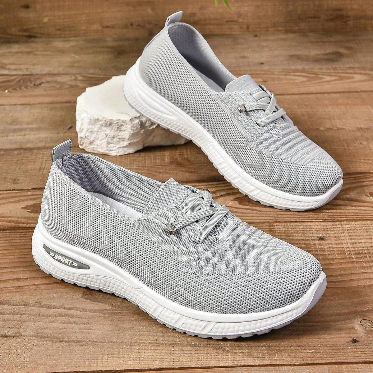 Grey women's slip-on sneakers with elastic lace detail and white soles