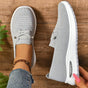Grey women's slip-on sneakers with elastic lace detail and white soles