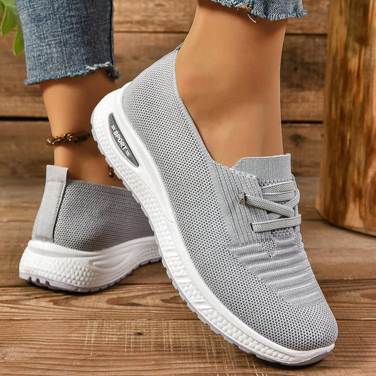 Grey women's slip-on sneakers with elastic lace detail and white soles