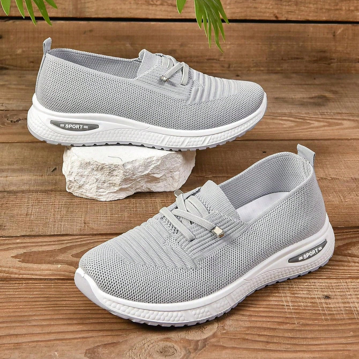 Grey women's slip-on sneakers with elastic lace detail and white soles