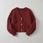 Women's cropped cable knit cardigan with V-neckline, buttons and long sleeves