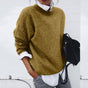 Women's relaxed crew neck sweater with long sleeves layered over a collared shirt