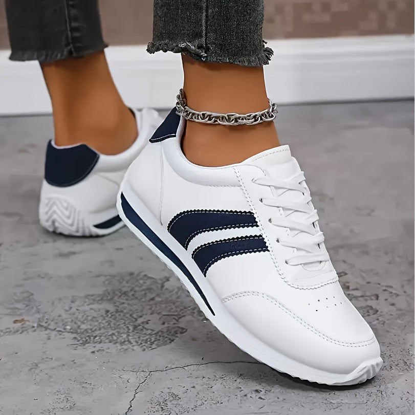White lace-up sneakers with navy side stripes and flat soles