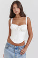 Woman wearing a cropped corset top with lace-trimmed straps, ruched tie-front bust and a boned panelled bodice