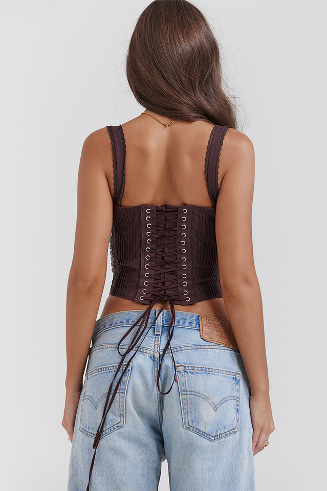 Woman wearing a cropped corset top with lace-trimmed straps, ruched tie-front bust and a boned panelled bodice