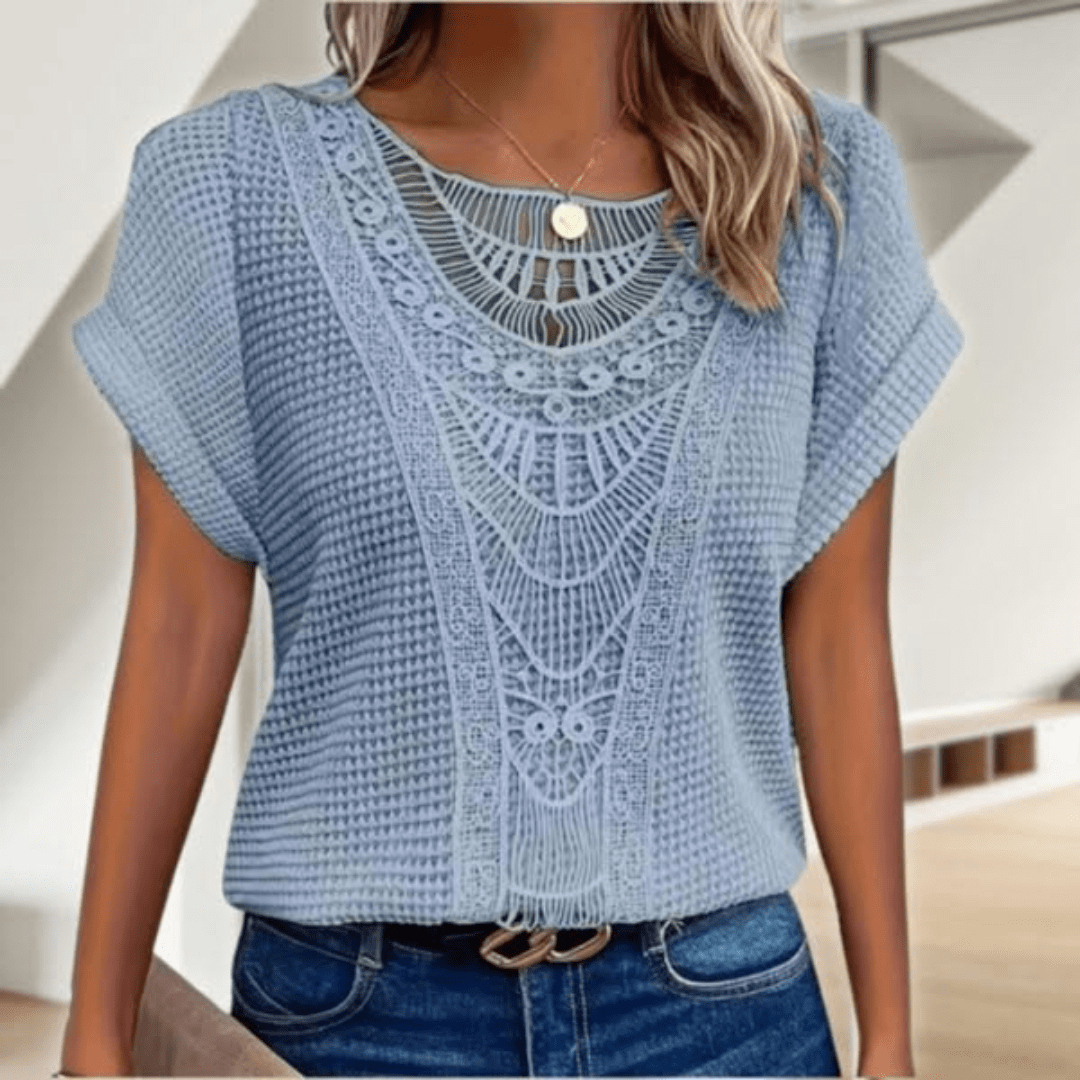 Woman wearing a relaxed waffle-knit top with an open crochet panel down the front and rolled cap sleeves