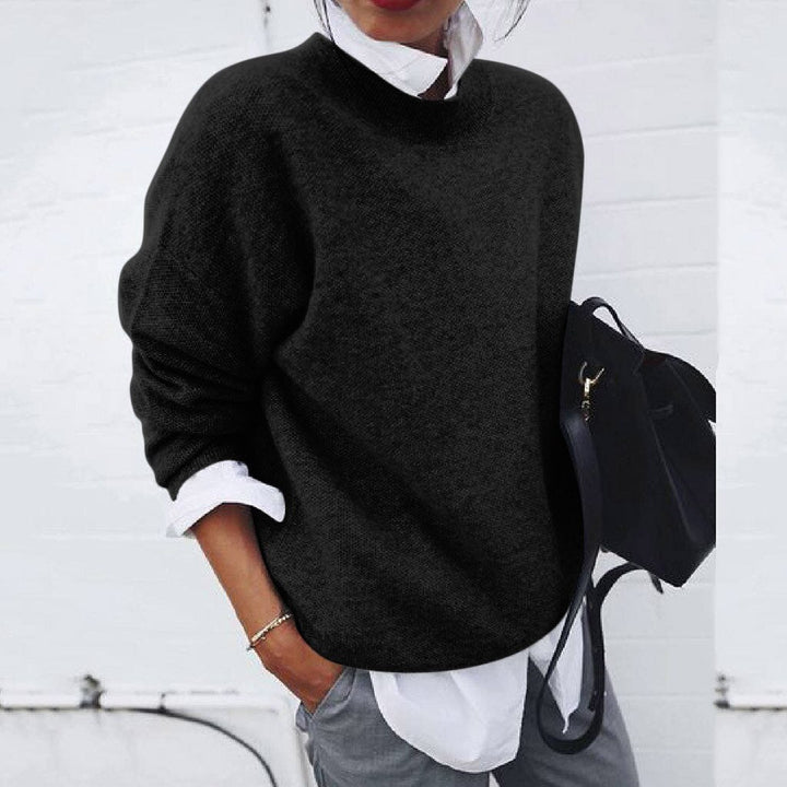Women's relaxed crew neck sweater with long sleeves layered over a collared shirt