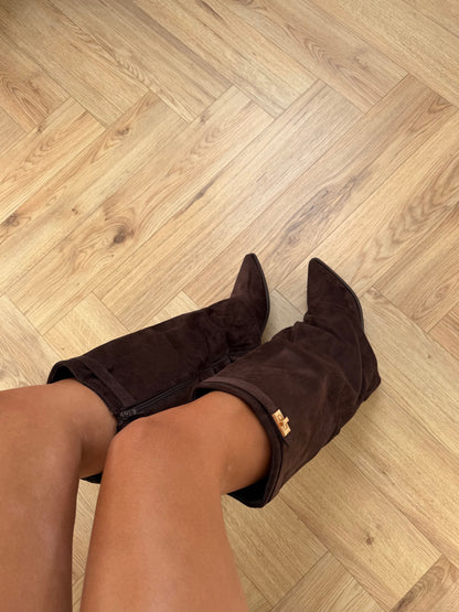 Women's brown knee-high boots with pointed toes, low heels and buckled shaft straps