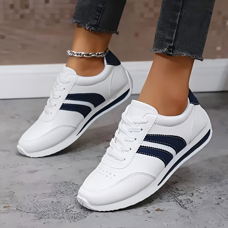 White lace-up sneakers with navy side stripes and flat soles