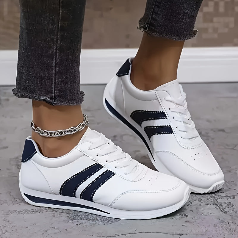 White lace-up sneakers with navy side stripes and flat soles