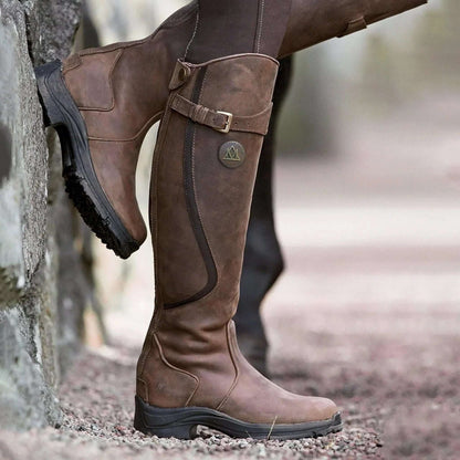 Women's tall riding boots with buckle straps, rounded toes and low heels