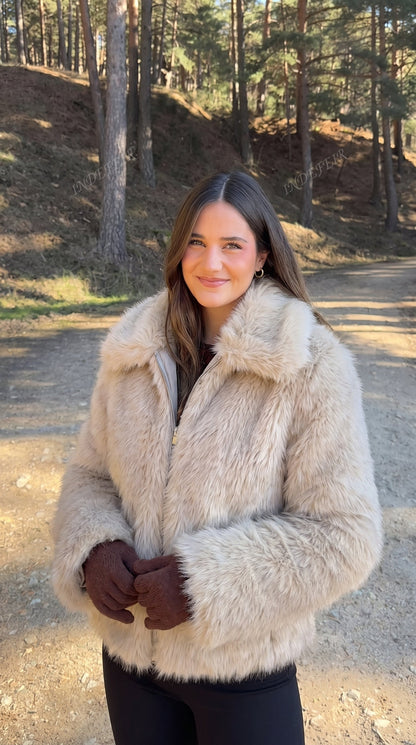 Woman wearing a beige faux fur bomber jacket with a wide collar and long sleeves