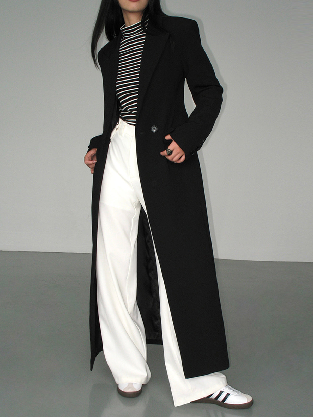 Women's long black single-breasted coat with notched lapels and front pockets