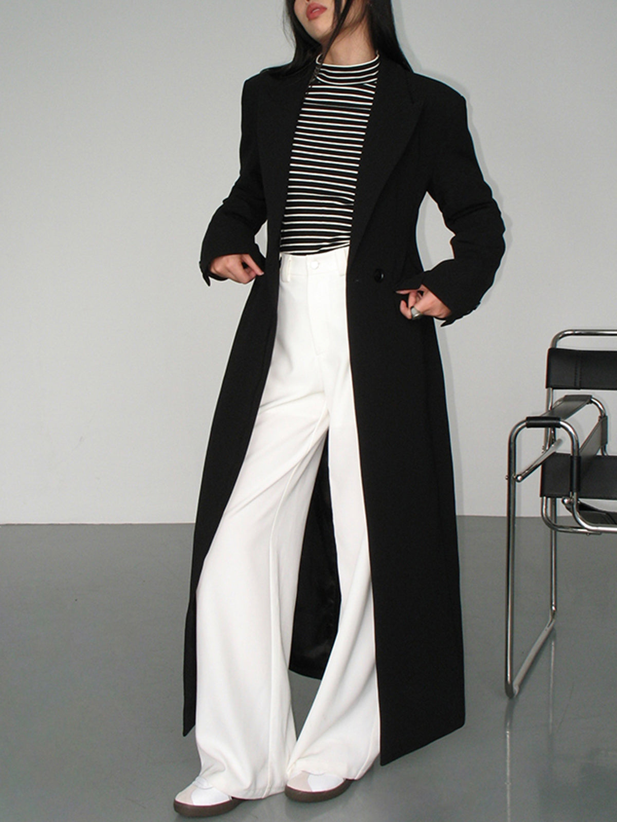 Women's long black single-breasted coat with notched lapels and front pockets