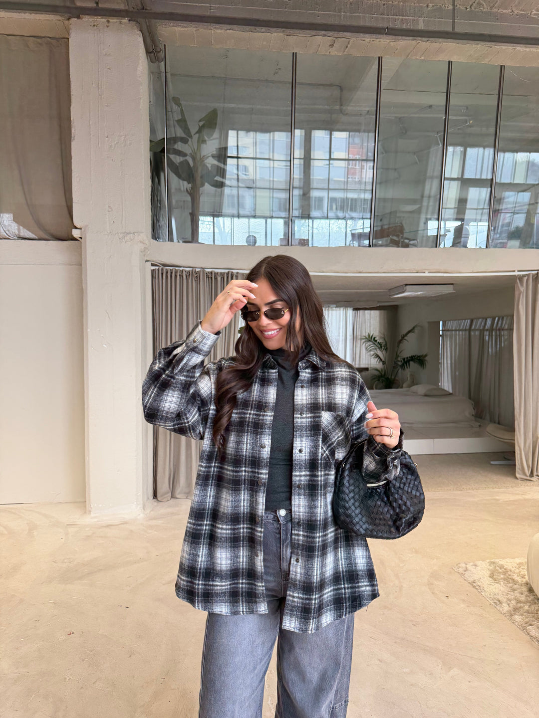 Women's black, gray and white plaid shirt layered over a dark turtleneck
