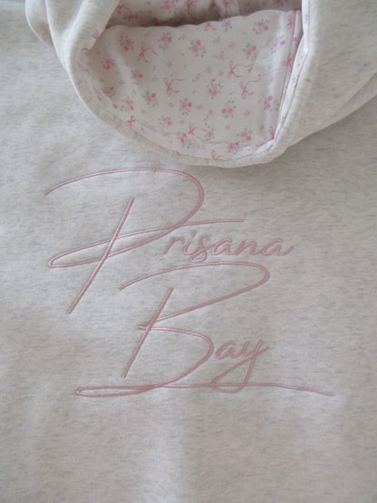 Light gray oversized hoodie with pink bow embroidery and floral hood lining