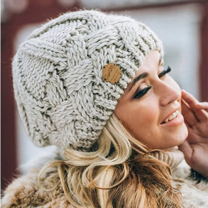Women's chunky cable knit beanie hat with folded edge and front patch