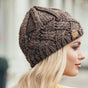 Women's chunky cable knit beanie hat with folded edge and front patch