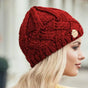 Women's chunky cable knit beanie hat with folded edge and front patch