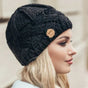Women's chunky cable knit beanie hat with folded edge and front patch
