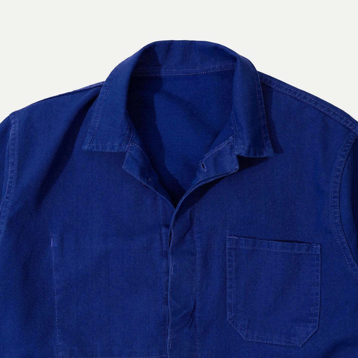 Men's blue button-front work jacket with collar and patch pockets