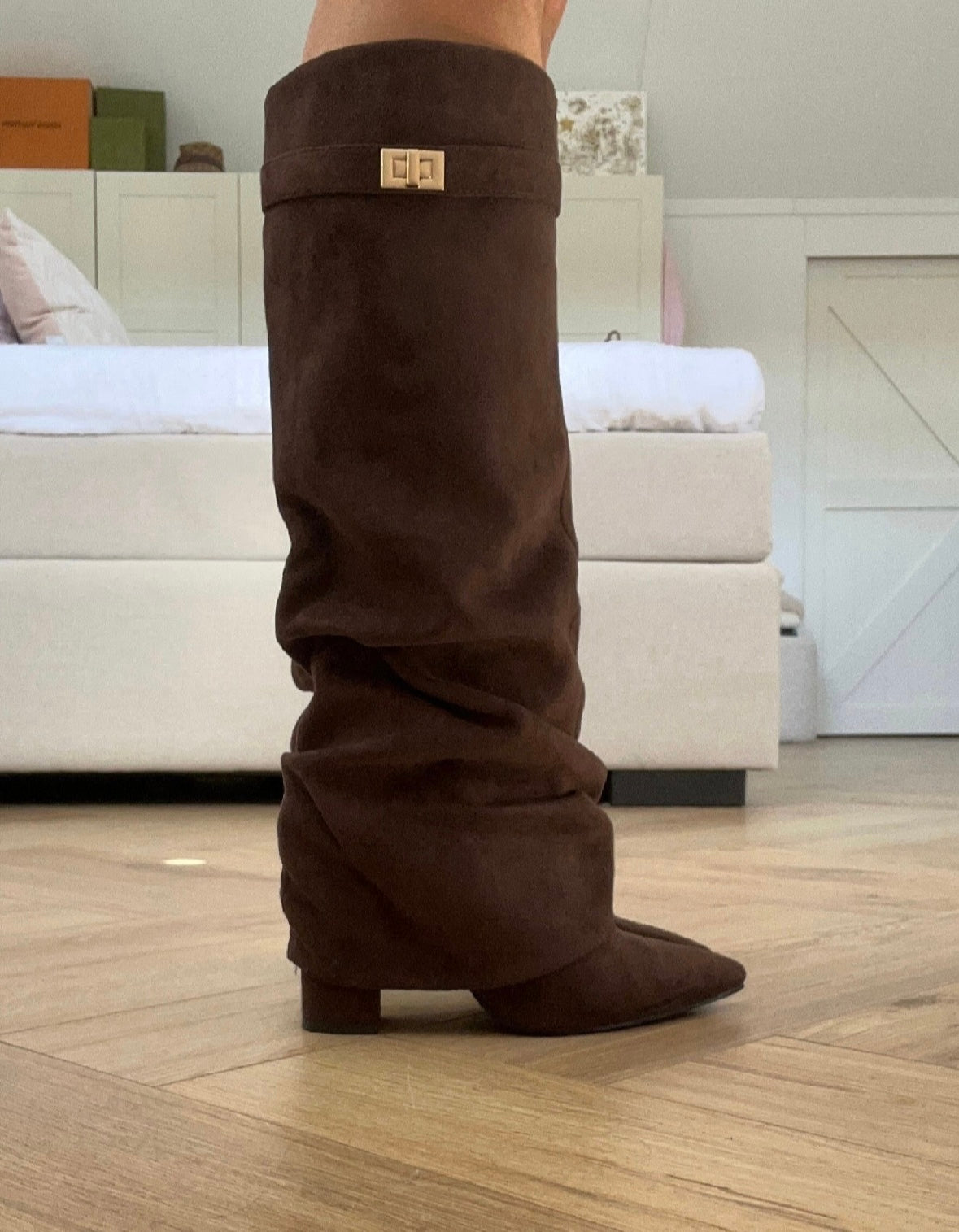 Brown women's slouch knee-high boots with pointed toes, low heels and buckle details