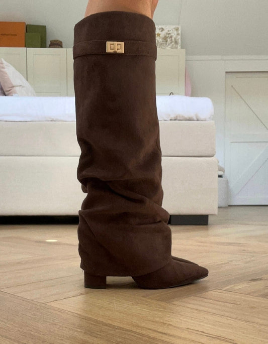 Brown women's slouch knee-high boots with pointed toes, low heels and buckle details