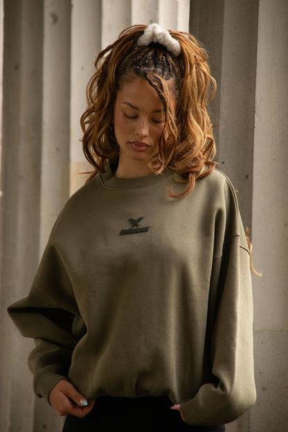 Women's green crewneck sweatshirt with raised chest logo and ribbed trims