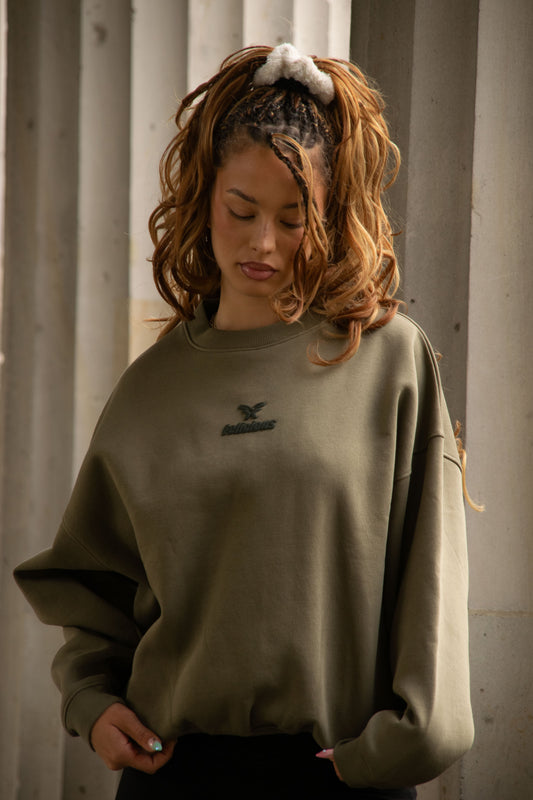 Women's green crewneck sweatshirt with raised chest logo and ribbed trims
