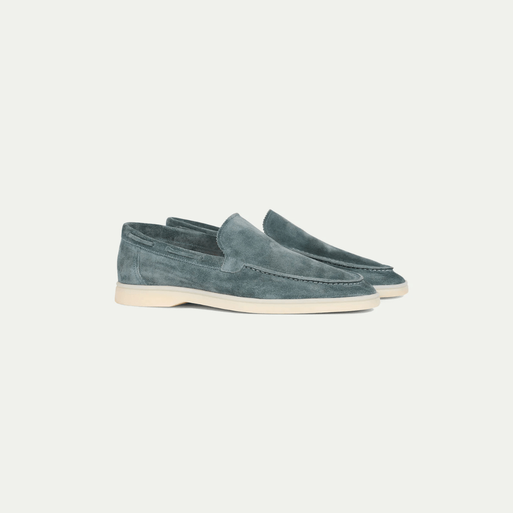Men's blue slip-on loafers with moc toe stitching and flat cream soles
