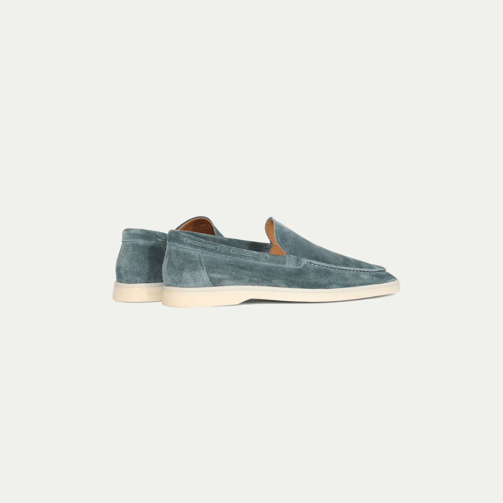 Men's blue slip-on loafers with moc toe stitching and flat cream soles