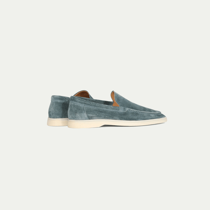 Men's blue slip-on loafers with moc toe stitching and flat cream soles