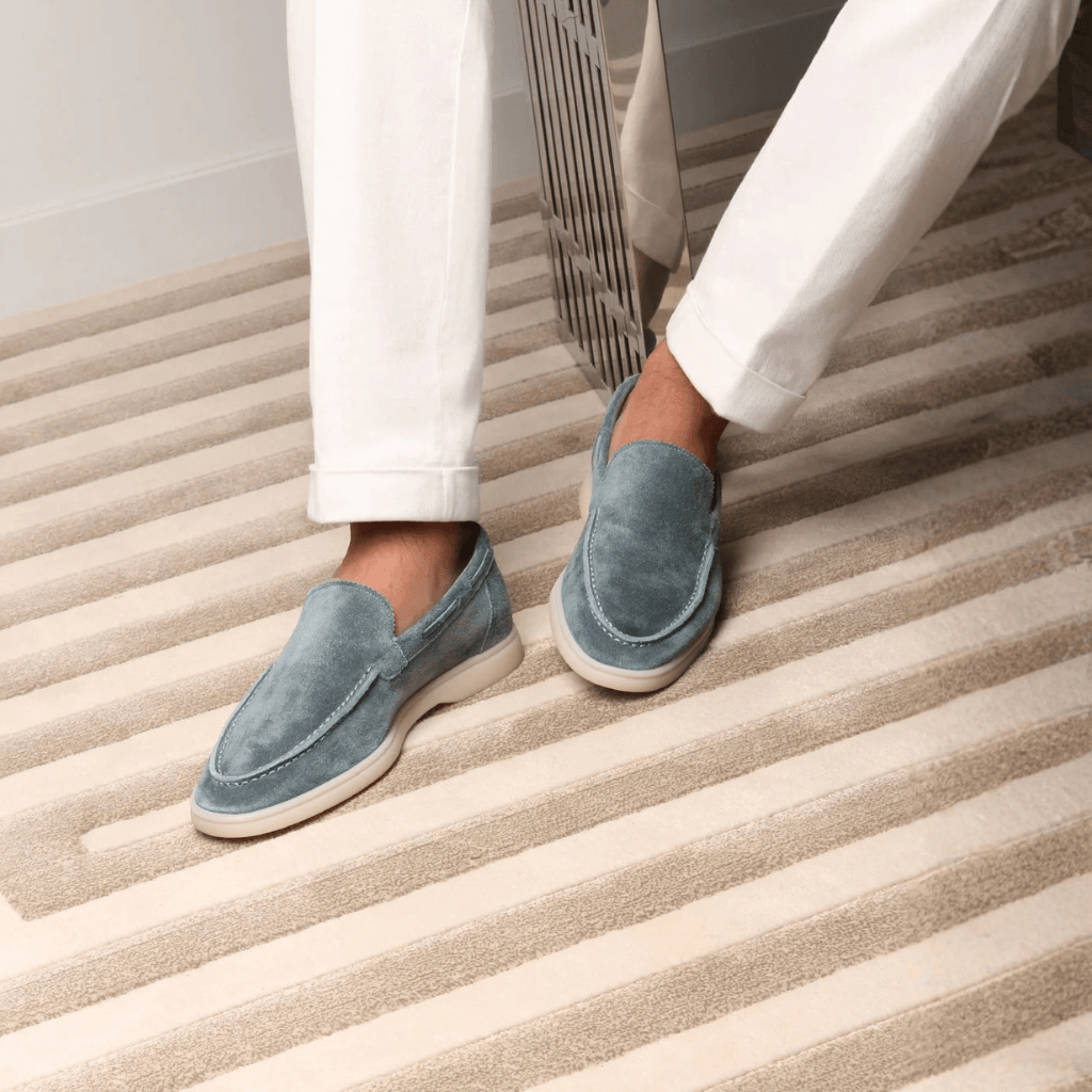 Men's blue slip-on loafers with moc toe stitching and flat cream soles