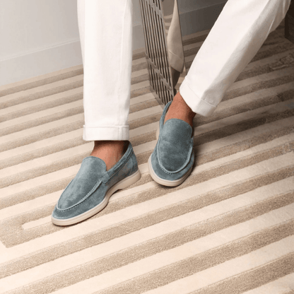 Men's blue slip-on loafers with moc toe stitching and flat cream soles