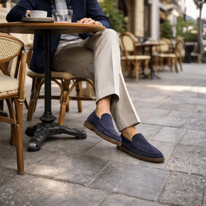 Navy men's penny loafers with moccasin stitching and brown sole