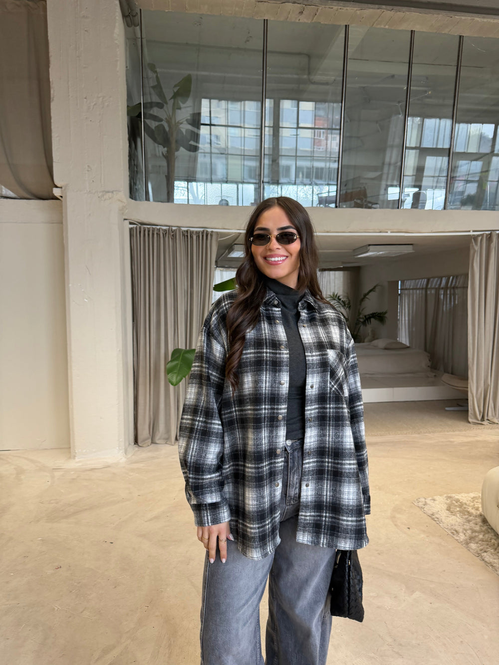 Women's black, gray and white plaid shirt layered over a dark turtleneck
