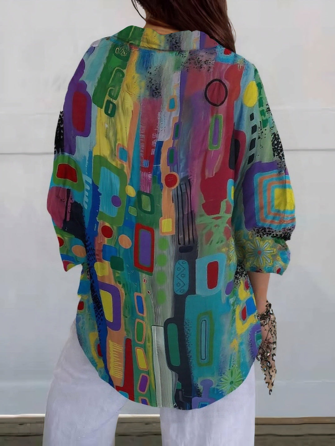 Woman wearing a multicolor abstract print blouse with collar and long sleeves
