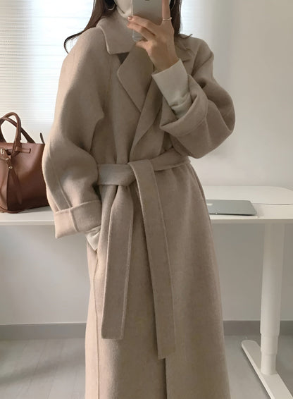 Women's long solid wrap coat with wide lapels and tie belt