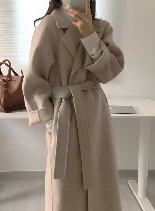 Women's long solid wrap coat with wide lapels and tie belt
