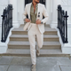 Man wearing beige two-piece slim fit suit with notched lapels and tapered trousers.
