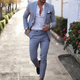 Man wearing beige two-piece slim fit suit with notched lapels and tapered trousers.
