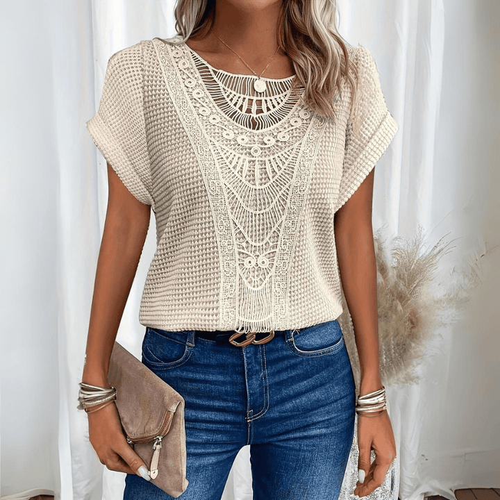 Woman wearing a relaxed waffle-knit top with an open crochet panel down the front and rolled cap sleeves
